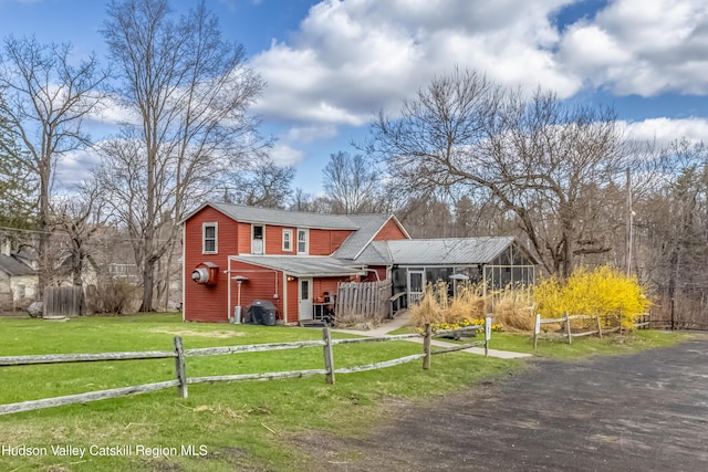 traditional-style home with a front lawn, roof with shingles, and fence private yard