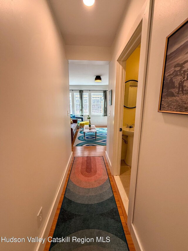 hall featuring baseboards and wood finished floors