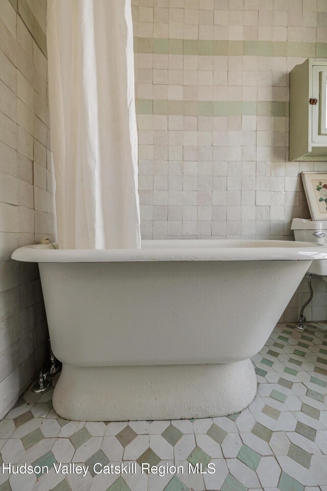 225 Robinson St, Hudson, NY 12534 - full bathroom featuring tile walls and a freestanding tub