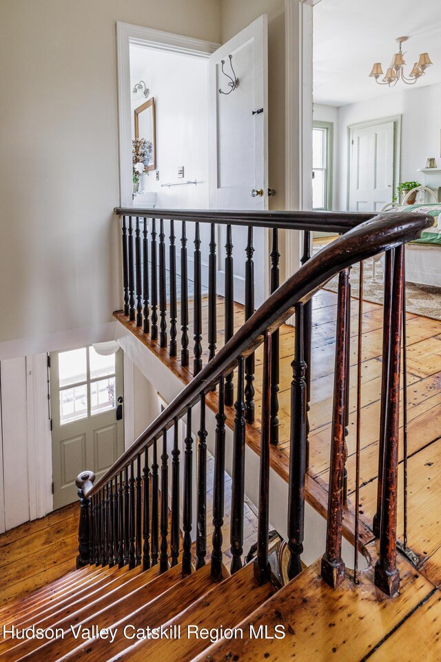 225 Robinson St, Hudson, NY 12534 - staircase with a chandelier and hardwood / wood-style flooring