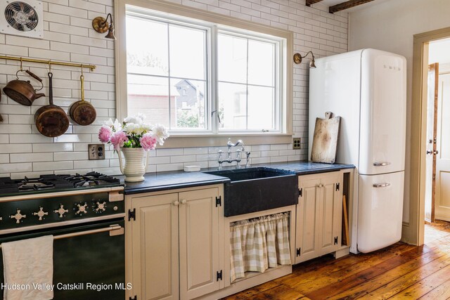 225 Robinson St, Hudson, NY 12534 - kitchen with black range with gas cooktop, freestanding refrigerator, dark countertops, and decorative backsplash