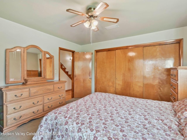 carpeted bedroom featuring ceiling fan and a closet