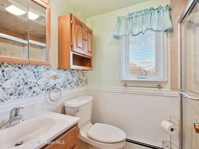 bathroom featuring vanity, toilet, a shower with shower door, and a baseboard radiator