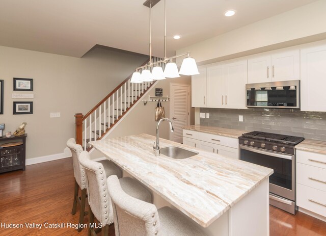 208 Hudson View Ter, Hyde Park, NY 12538 - kitchen featuring appliances with stainless steel finishes, tasteful backsplash, dark wood-type flooring, light stone countertops, and white cabinets