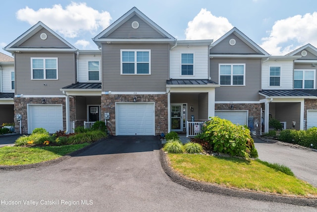 208 Hudson View Ter, Hyde Park, NY 12538 - view of property with stone siding, a standing seam roof, an attached garage, driveway, and a metal roof
