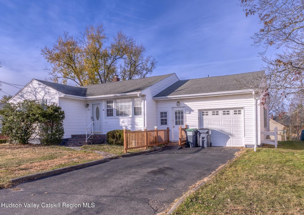 single story home featuring a front lawn and a garage