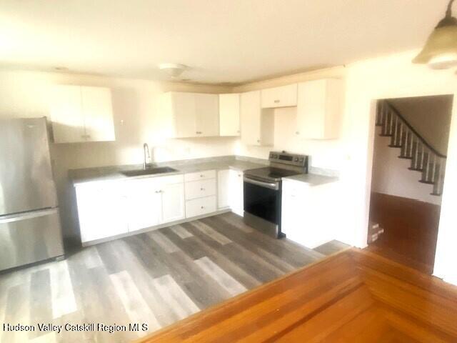 kitchen featuring white cabinetry, sink, dark wood-type flooring, and appliances with stainless steel finishes