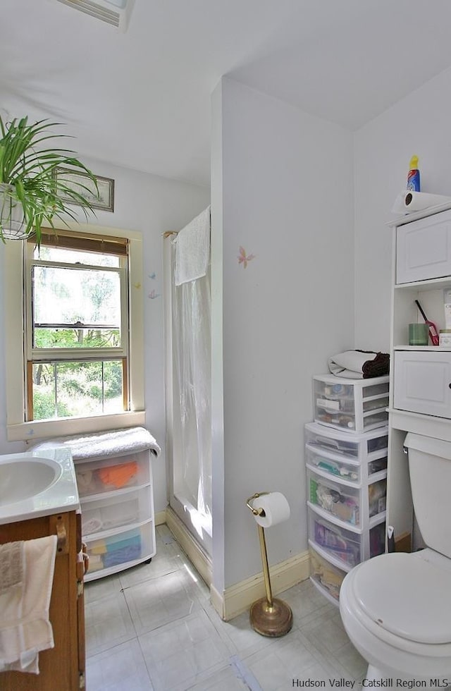 bathroom featuring a shower with shower curtain, vanity, and toilet