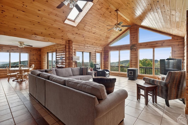 187 Mt Jeffereson Rd, Jefferson, NY 12167 - living area featuring ceiling fan, light tile patterned floors, high vaulted ceiling, a skylight, and a wood stove