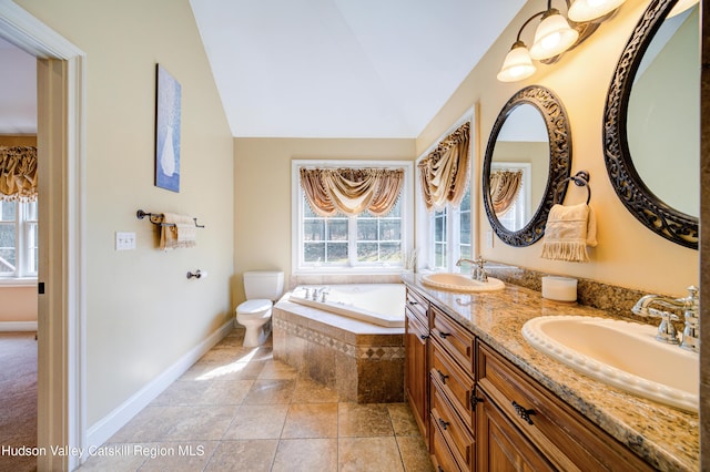 full bathroom with a sink, a bath, plenty of natural light, and vaulted ceiling