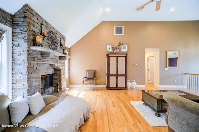 living area with visible vents, light wood-style flooring, baseboards, and a fireplace