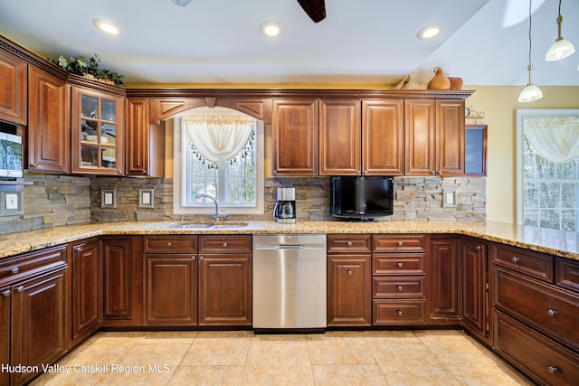 kitchen with glass insert cabinets, backsplash, appliances with stainless steel finishes, pendant lighting, and a sink