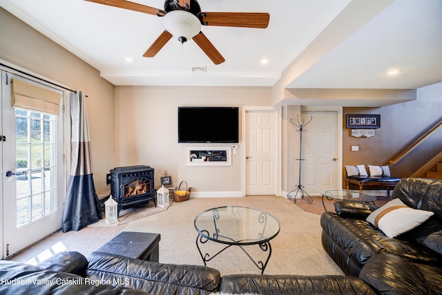 living area with recessed lighting, a wood stove, stairway, and carpet floors