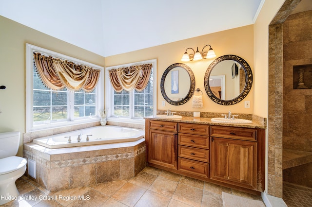 bathroom with a sink, toilet, double vanity, and a garden tub