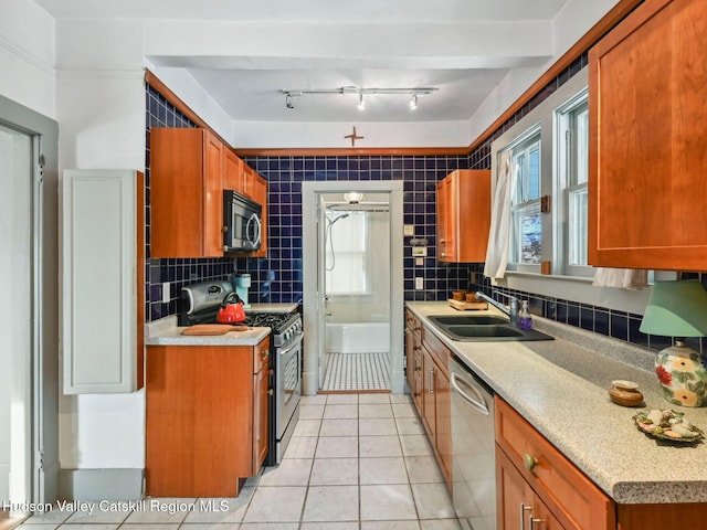 kitchen with light tile patterned floors, stainless steel appliances, tasteful backsplash, and sink