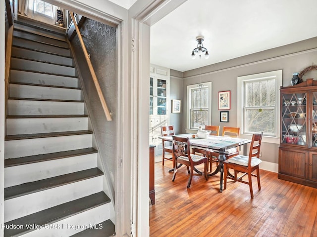 dining room with wood-type flooring and an inviting chandelier