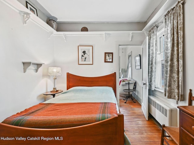 bedroom featuring wood-type flooring and radiator