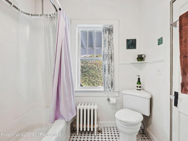 bathroom with wooden walls, shower / bath combination with curtain, toilet, and radiator