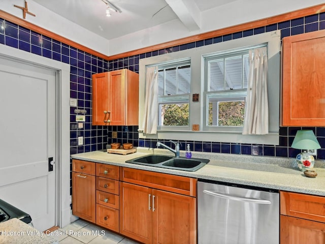 kitchen featuring stainless steel dishwasher, light tile patterned floors, sink, and tasteful backsplash