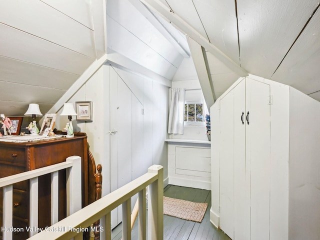 additional living space with wood walls and vaulted ceiling