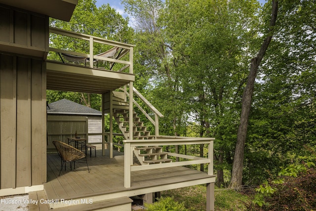 wooden terrace featuring stairway and view of scattered trees