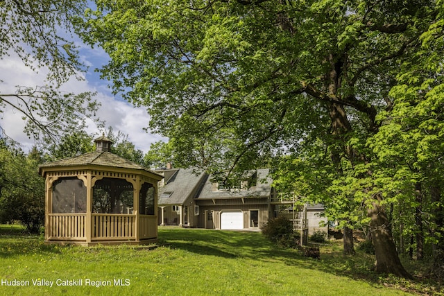 view of front of house featuring a gazebo, a front yard, and an attached garage