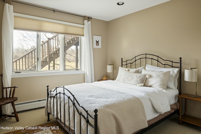 carpeted bedroom featuring a baseboard heating unit