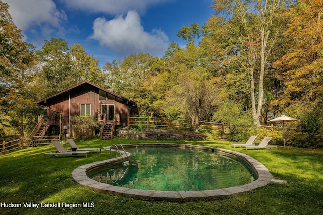 view of swimming pool featuring a yard