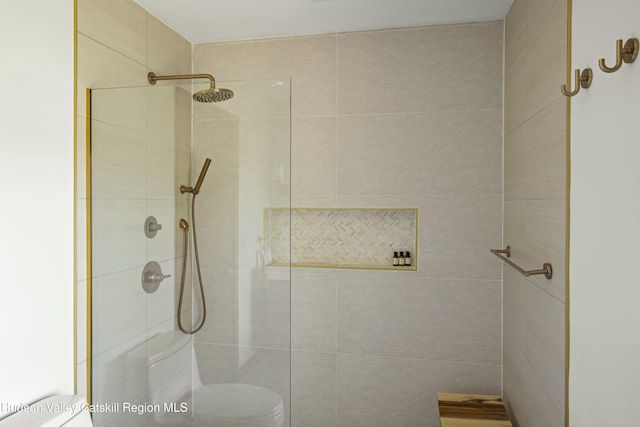 bathroom featuring toilet and tiled shower