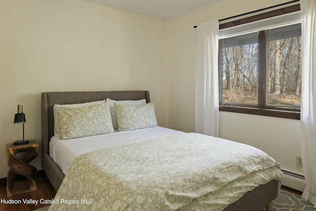 bedroom with hardwood / wood-style flooring and baseboard heating