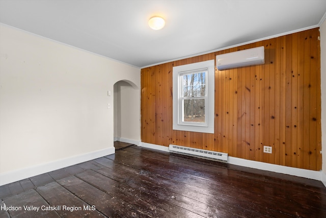 unfurnished room featuring dark wood-type flooring, wood walls, crown molding, a wall mounted AC, and a baseboard heating unit