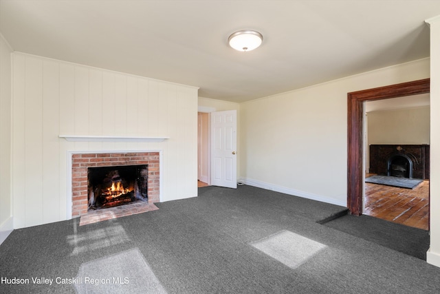 unfurnished living room featuring a fireplace and dark colored carpet