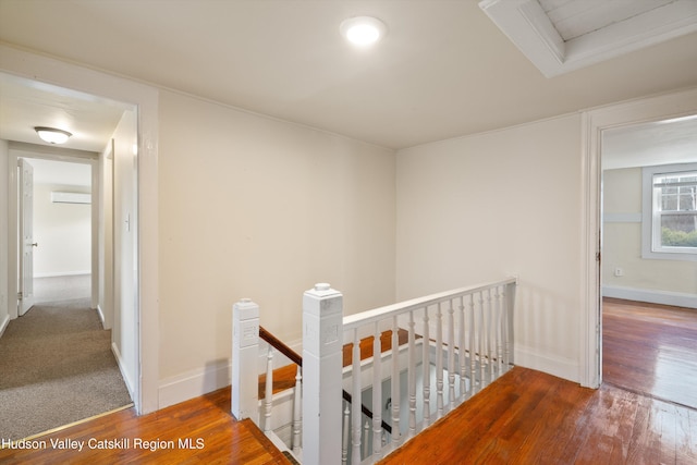 corridor with hardwood / wood-style floors and a wall unit AC