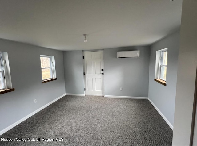 unfurnished room with a wall mounted air conditioner and carpet flooring