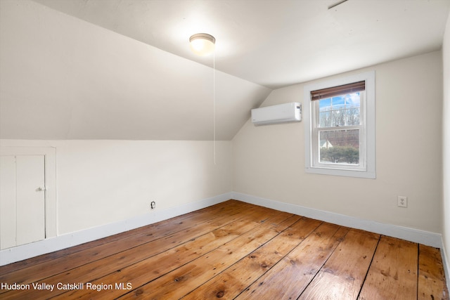 bonus room featuring hardwood / wood-style flooring, vaulted ceiling, and a wall unit AC