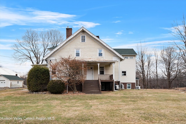 back of property featuring a lawn and covered porch