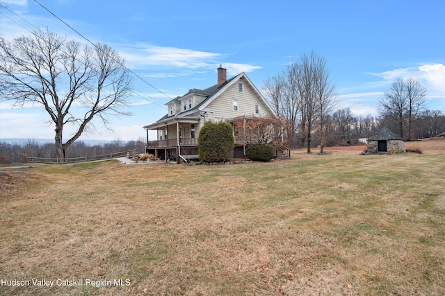 view of side of home with a yard, a gazebo, and covered porch