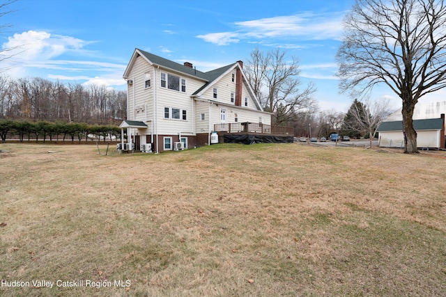 view of side of home featuring a wooden deck and a lawn