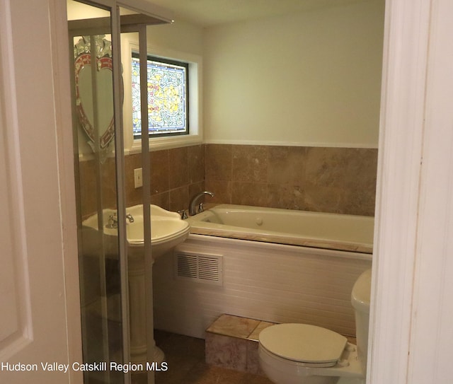 bathroom featuring visible vents, toilet, and a bath