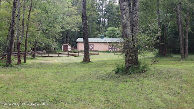 view of yard with fence and an outdoor structure