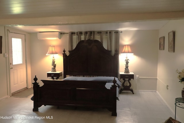 bedroom featuring a wall unit AC and baseboards