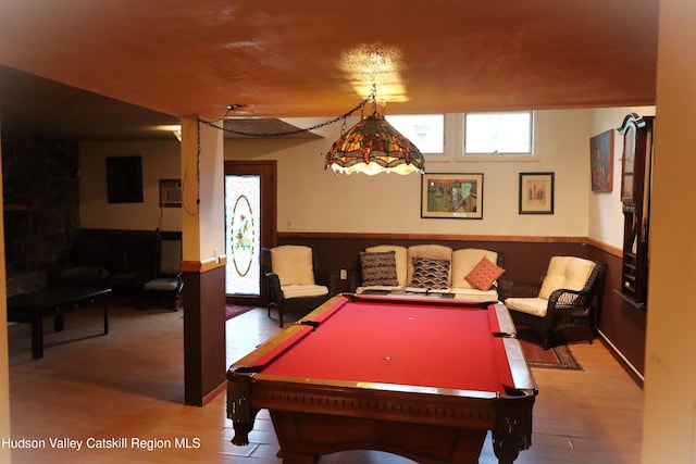 game room with a wainscoted wall and light wood-style floors