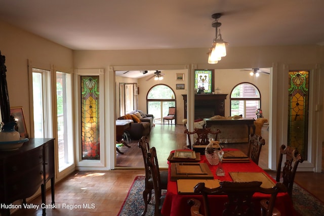 dining room featuring ceiling fan and a fireplace