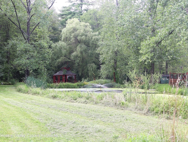 view of yard with a wooded view and a gazebo