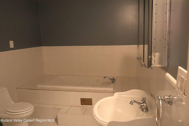 bathroom with tile patterned floors, a sink, toilet, and a bath