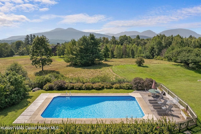 view of pool featuring a mountain view and a lawn