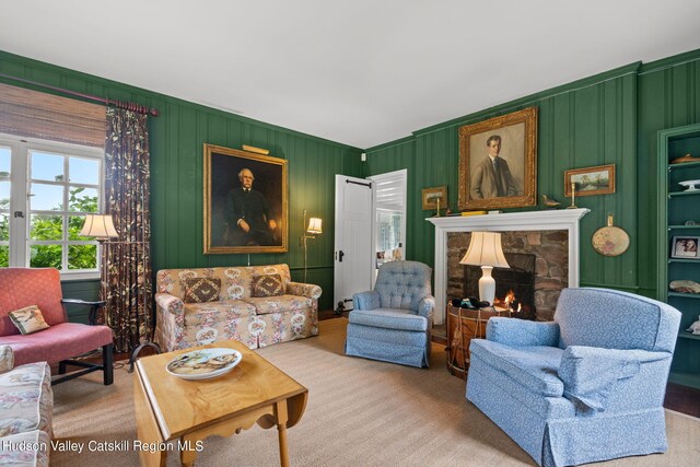 carpeted living room featuring a stone fireplace