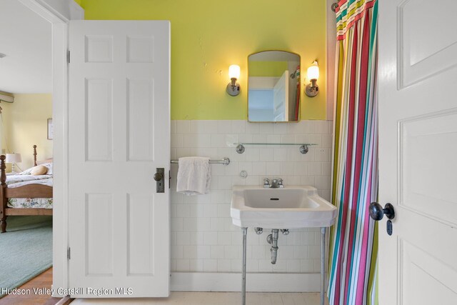 bathroom with tile walls and sink