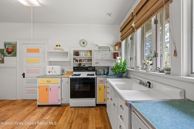 kitchen featuring light hardwood / wood-style floors, sink, white cabinetry, and white stove