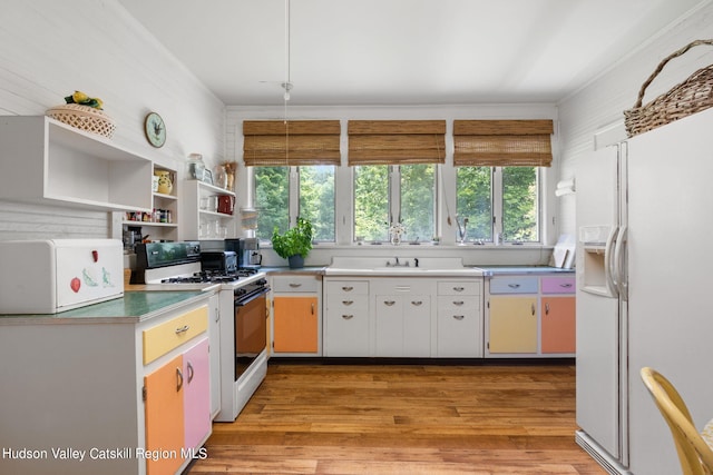 kitchen with white cabinetry, light wood-type flooring, white appliances, and crown molding